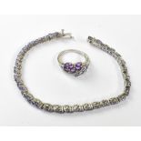 A silver tennis bracelet set with blue pear-shaped tanzanite stones and a matching silver dress