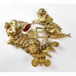 A 9ct gold charm bracelet with approximately twenty-five gold charms, to include seal fobs, harp,