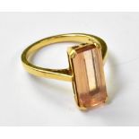 An 18ct yellow gold ladies' dress ring with a large emerald cut peach tourmaline, size P1/2,