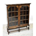 An early 20th century oak two-door glazed display cabinet,