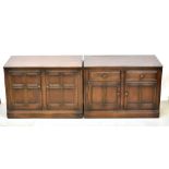 ERCOL; two dark dresser bases, one with a pair of fielded and panelled cupboard doors,