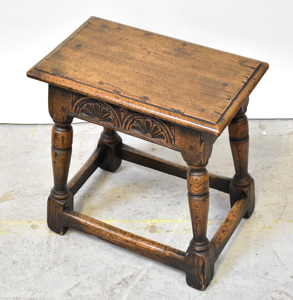 An oak joint stool with carved foliate panels to the apron,