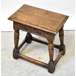 An oak joint stool with carved foliate panels to the apron,