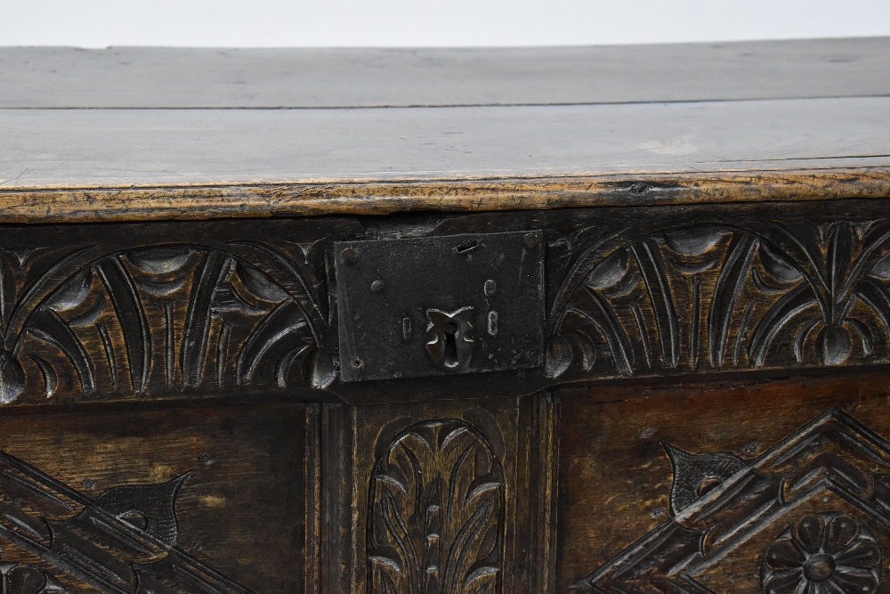 A Georgian oak panelled coffer with plank top and carved geometric and floral panels to the front, - Image 2 of 5