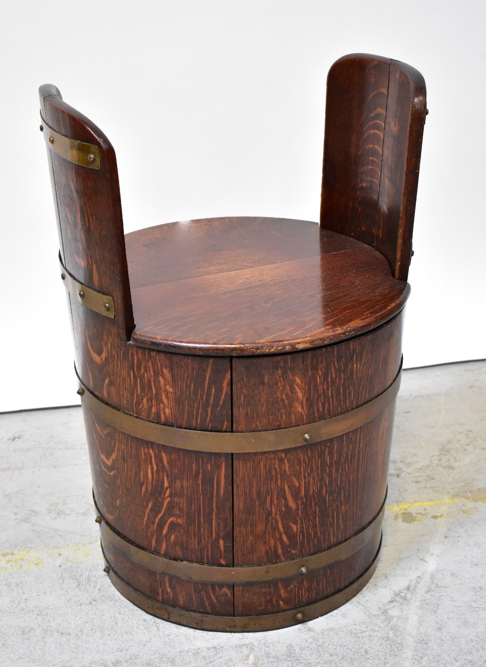 A lidded tub stool fashioned from a brass bound oak coopered barrel, height 63cm, diameter 44cm.