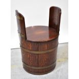 A lidded tub stool fashioned from a brass bound oak coopered barrel, height 63cm, diameter 44cm.