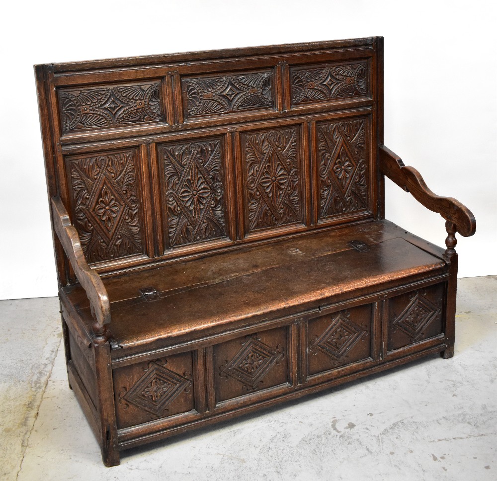 A Georgian carved oak settle,