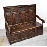 A Georgian carved oak settle,