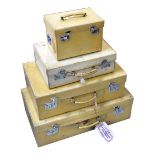 Three vintage cream vellum-effect suitcases, each with silk lining,