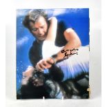 ROGER MOORE; a coloured photograph bearing the James Bond actor's signature, 25 x 20cm, unframed.