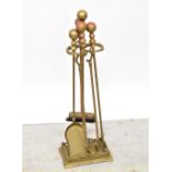 A contemporary brass four-piece fireside companion set, comprising poker, tongs, pan and brush,