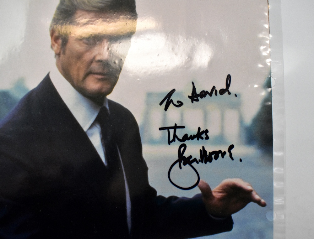 ROGER MOORE; a coloured photograph bearing the James Bond actor's signature, 25 x 20cm, unframed. - Image 2 of 2