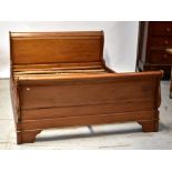 A contemporary mahogany-framed king size sleigh bedstead with slatted base.