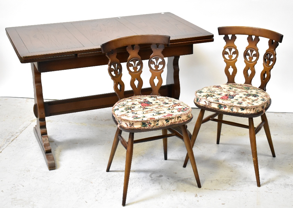 ERCOL; a dark stained extending dining table with two integral leaves beneath the rectangular top,