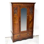 An Edwardian mahogany and walnut single-door wardrobe, stepped frieze above central mirrored door,