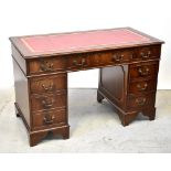 A reproduction mahogany nine-drawer twin pedestal desk, with inset gilt-tooled red leather panel,