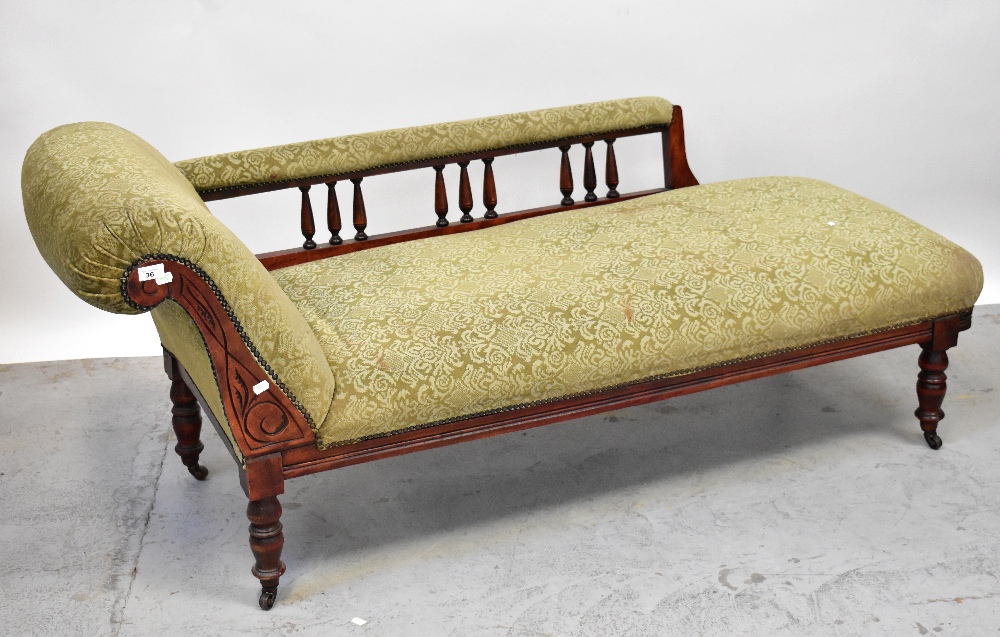 A Victorian mahogany framed chaise longue, scrolling back with curved side rail to carved frieze,