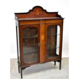 An Edwardian inlaid mahogany display cabinet with galleried arched inlaid top above a pair of