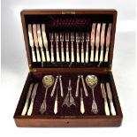 A late Victorian walnut cased dessert set comprising twelve knives and forks with wrythen twisted