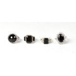 Four sterling silver dress rings, each ring featuring black spinel,