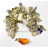 A hallmarked silver charm bracelet with forty plus charms, including a birdcage, folding comb,