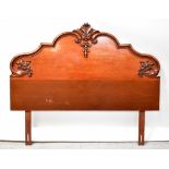 A 19th century mahogany headboard, shaped domed top with applied carved floral decoration,