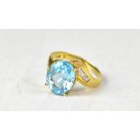 A 14ct yellow gold ring set with central oval topaz and three small white stones to each shoulder,