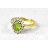 An 18ct yellow gold ring set with oval peridot and diamond surround, size O1/2, approx 4.5g.