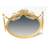 An early 20th century Neo-Classical style bevel edge oval mirror,