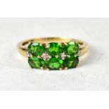 A 9ct gold ring set with two rows of three chrome diopside claw set oval stones and four tiny