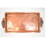 An Arts and Crafts copper rectangular tray with blue and green enamel panels to the shaped handles