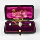 A 15ct bar brooch set with central claw set white opal, with flashes of green and blue, approx 0.