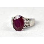 A 9ct white gold ring with claw set oval fissure-filled ruby,