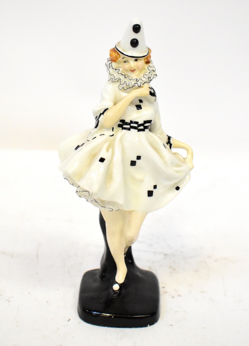 ROYAL DOULTON; an early porcelain figurine, HN644 'Pierette', female harlequin on base,