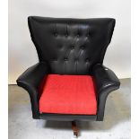 A mid-20th century leather button back swivel wing armchair,