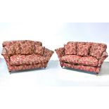 A pair of contemporary three-seat sofas upholstered in maroon fabric, with gold floral sprays,