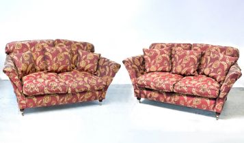 A pair of contemporary three-seat sofas upholstered in maroon fabric, with gold floral sprays,