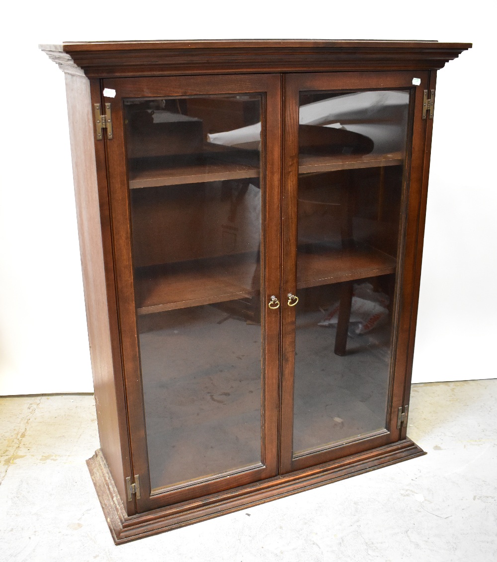 A reproduction oak two-door glazed cabinet with two internal shelves,