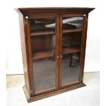 A reproduction oak two-door glazed cabinet with two internal shelves,