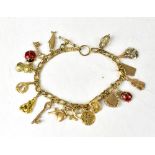 A charm bracelet comprising seventeen mixed gold charms, to include examples marked '9CT',