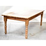 A rustic stripped pine farmhouse kitchen table, raised on turned supports, 77 x 213 x 104cm.
