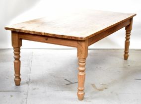 A rustic stripped pine farmhouse kitchen table, raised on turned supports, 77 x 213 x 104cm.