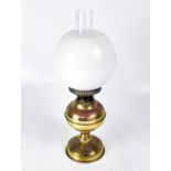 A brass oil lamp with opaque shade and funnel, height 51cm.