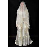 A 1960s full-length wedding dress, with fitted bodice and V-neck collar,