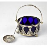 An Edwardian hallmarked silver sugar bowl with pierced sides and swing handle,