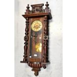 A Vienna-style beech and walnut spring-driven wall clock, the chapter ring set with Roman numerals,
