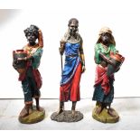 A pair of painted resin figures, each carrying water urns and a decorative figure of a Masai female,