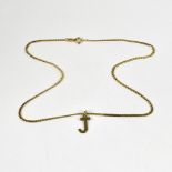 A 9ct gold flat curb dainty chain necklace, with hoop fastener and a 9ct gold initial 'J' pendant,
