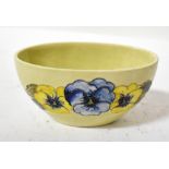 WALTER MOORCROFT; a mid-20th century pottery dish of oval form, decorated with tube lined pansies,