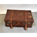 An early 20th century leather suitcase with carrying handles to the side, initialled 'F.W.